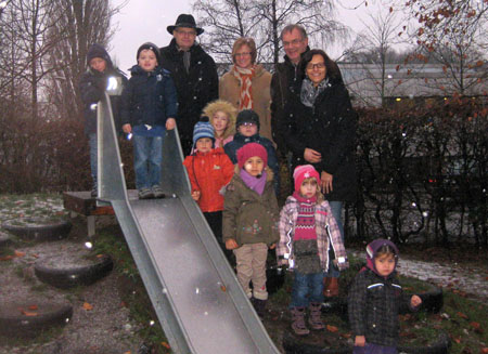 Die Kinder freuen sich über die neue Rutsche an der Hermann- Löns-Straße zusammen mit ihrer Leiterin Helga Osburg (re.), Hans-Georg Hunstig und Martina Frenzel vom Vorstand "Kirche lebt. Schloß Neuhaus e.V." sowie Konrad Bröckling (li.) vom Rat der Einrichtung.